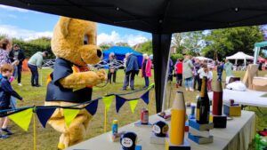 Someone dressed up as a bear playing on a hoopla stall